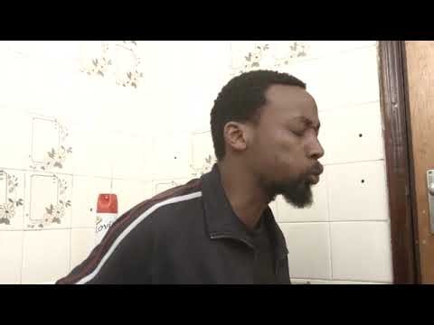 Black man pooping runs out of toilet paper.