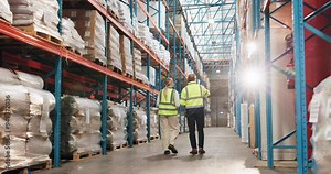 Logistics, team and people in warehouse inspection with checklist for export stock distribution from back. Inventory, planning or workers walking in factory together for project management discussion