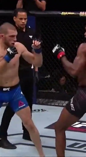 Inside the UFC octagon two fighters exchange fast straight punches over the center UFC logo crisp