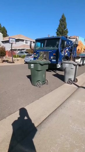 Blue Garbage Truck Mechanically Empties Trash Bins