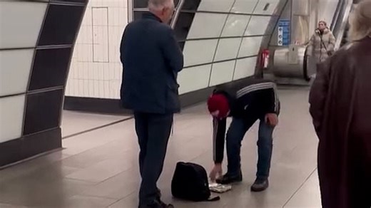 Moment brazen thief steals money from busker on London underground