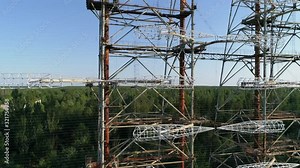 Aerial view of the DUGA radar station near the city of Chernobyl-2 among the forest. Exclusion Zone. Camera booming up. 4K drone footage. Close-up.