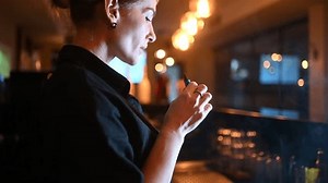 Close up side view of woman vaping and exhaling smoke