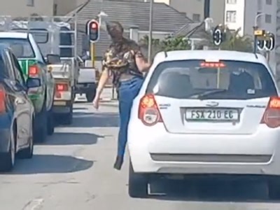 VIDEO: Woman hangs out of car window to get attention