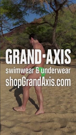 Bodybuilder oiling up in a speedo on the beach in Maui