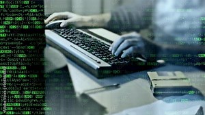 Random characters that look like the source code of a computer program, scrolling down, overlayed on the hands of a man typing on a pc keyboard.