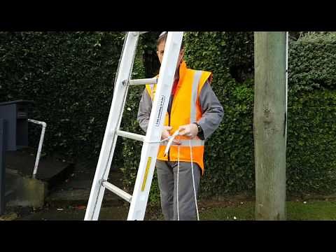 Securing a ladder at the base of a telephone pole