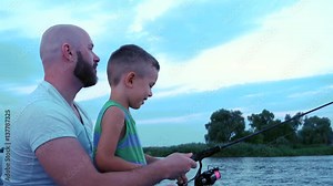 Father and son fishing rod catch a fish sitting in a boat, happy father teaches the child to fish, good dad, summer vacation, family spends a weekend in nature