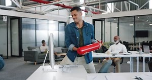 Anger, frustrated and fire extinguisher with a business man breaking a computer during a breakdown at work. Compliance, glitch and 404 with an angry male employee smashing a desktop in the office