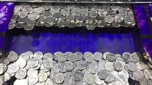 Vintage coin pusher arcade game moves and pushes quarters