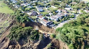 The scene in May as homes teetered on the edge of a cliff