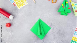 Step by step stop motion instructions how to make origami christmas tree. Kids art-project. Paper craft