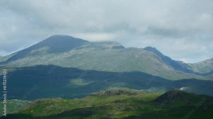 Thick cloud skimming mountain tops as cloud shadows race across the countryside. Timelapse 60x. English Lake District, Wasdale, Cumbria, UK