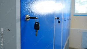Dressing room in gym with boxes for clothes and keys in lock. Multiple closed lockers are visible in background. School change room. modern fitness center. Blue metalic wardrobe rows. 4 k video
