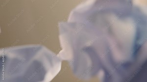 Looking up view, inside trash bin, captures crumpling a piece of paper with scribble markings, suggesting a mistake concept or junk idea concept. This also emphasizes the recycling and reuse concept.