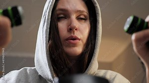 Woman workout at home. Purposeful woman with sweat on her face does cardio workout at home in evening and thinks about something. Bottom view, slow motion and close-up