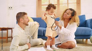 African American couple using stethoscope playing with daughter in house.