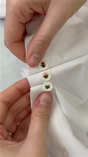 Mood Fabrics | Fabric & Sewing on Instagram: "Take a break from your feed and stitch something beautiful 🌸 In this soothing embroidery button art tutorial, watch simple white buttons transform into delicate floral designs using colorful thread. This easy hand embroidery technique is perfect for relaxing, getting creative, and adding artistic details to your sewing projects. Save this video for later, try it yourself, and tag #MadeWithMood to be featured. #MoodFabrics #EmbroideryButtonArt #HandE