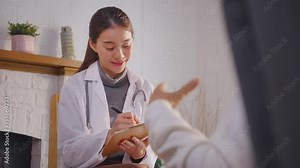 Asian young caregiver nurse examine and listen to senior woman patient.