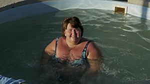 Woman with overweight relaxing in the pool in summer, 4k