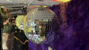 4k footage of rotating disco ball or glitter ball in the interior of a disco dance floor or a club. Disco ball is used to reflect lights and suspended hanging from ceiling to add ambience of reflectio