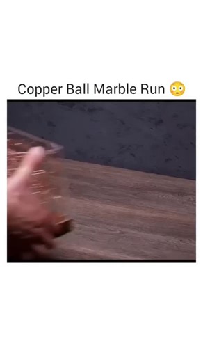LuckEditZ on Instagram: "The video showcases a copper wire maze game housed within a transparent acrylic box placed on a wooden base. It begins with a hand setting up the maze, followed by a close-up of a container filled with silver balls. The balls are then seen rolling through the intricate maze structure. The box is rotated to display the maze from all sides, with the camera capturing close-ups of the balls navigating the complex network of wires. Some balls fall off at the bottom edge. The 