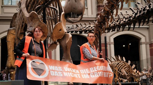 Climate activists glue themselves to dinosaur exhibit at Berlin museum