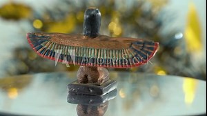 Dreamy close-up shot of a Cleopatra statue with wide open wings, hazy golden depth of field, ancient, Egyptian historical ruler, antique artwork of a goddess, rotating 360 slow 4K video pan right