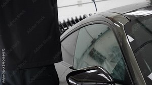 Close up of paint protection film installation on front bumper of modern luxury car. PPF is polyurethane film applied to car surface to protect the paint from stone chips, bug splatter, and abrasion.