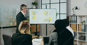 Business man explaining presentation on whiteboard about indicators on economic growth for attentive motivated subordinates Stock Video
