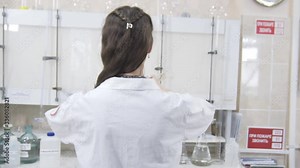 Female scientist analyzes liquid in distillery laboratory researcher. Woman stands with her back to camera. Mixing chemicals and alcoholic beverage. Slow motion Stock Video