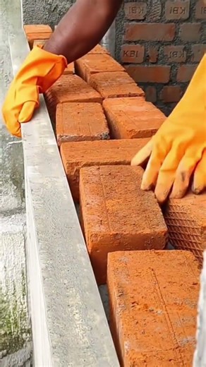 How is the process of making walls in a building using bricks and cement?
