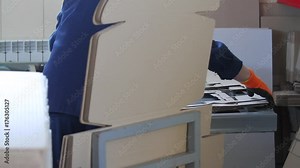 Cutting the cardboard box with a press tool under the press. Mold for a cardboard box. Manufacture of cardboard boxes. Close up box die cutting mold on manufacture of cardboard boxes