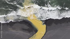 Aerial video over river dune with special colors spilling into ocean, Iceland