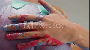 Young couple man and woman doing body art with colourful paints on each other close-up macro.Man and woman drawing colours paint on their bodies. Body art therapy with many various of paints. Painting