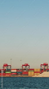 Container cranes glide along rows of shipping containers, efficiently loading and unloading cargo for import and export in a vibrant port setting Stock Video