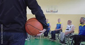 selector I explain new tactics to basketball players in wheelchairs, persons with disabilities sitting in wheelchairs listening to the selector