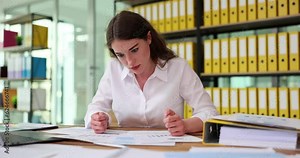 Irritated worker nervously beats table with fists and jams hated papers with analytics. Businesswoman frustrated with decline in sales of enterprise