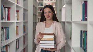 Young teacher with folio stack in college library. Happy librarian recommends literature for reading in bookstore. Pretty lady with books collection
