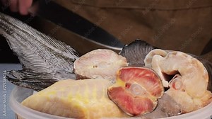 Fresh fillet sturgeon fish on desk close-up. Roast healthy food concept. Chef preparing to cook sturgeon, hake, cod fish steak pieces fillet with spice on grill. Healthy diet food