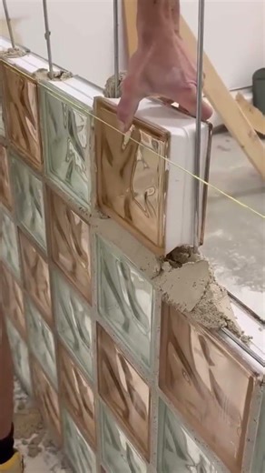the process of installing bricks coated with colored glazed ceramics for making building walls