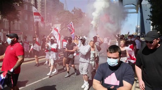 Anti Migrant protestors are arrested after blocking roads and setting off flares in Canary Wharf near the Britannia International Hotel