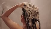 Woman washing hair with shampoo