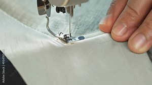 A person operates a sewing machine, skillfully stitching together a vibrant piece of fabric, showcasing creativity and craftsmanship in the art of sewing.