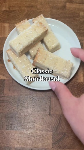 Shortbread is a holiday must! Don’t let this simple biscuit fool you, they are buttery, melt in your mouth and necessary for your cookie boxes! Ingredients - 1 cup plus 2 tbsp (250 g) European butter, room temperature - 1/2 tsp vanilla (optional) - 1/2 tsp kosher salt - 1/2 cup plus 2 tbsp (125 g) granulated sugar - 3 cups (360 g) all purpose flour - 2 tbs (16g) corn starch - Sanding or coarse sugar for on top Instructions 1. Pre-heat your oven to 325 degrees F and line a 8x8 square tray with pa