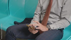 Close up businessman sitting on the seat using modern smartphone to internet checking news on electric train, Passenger commuting by railway transport, the man middle age texting on mobile phone