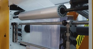 The process of producing plastic film. Polyethylene moves along the production line. Close-up.