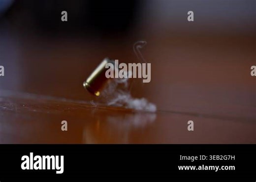 One bullet shell casing falling to the wooden surface in slow motion. Fired brass casing bouncing after shot, close up action detail. High quality 4k footage Stock Video Footage - Alamy