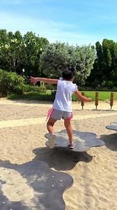 Playground for kids in a park, busy with excited and joyful children having fun and playing on merry-go-round, slide, playhouse and swing and running around.
