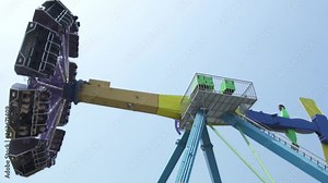 People riding on extreme attraction in amusement park. Happy friends having fun on thrilling roller coaster ride in amusement park. Happy leisure, vacation, weekend concept